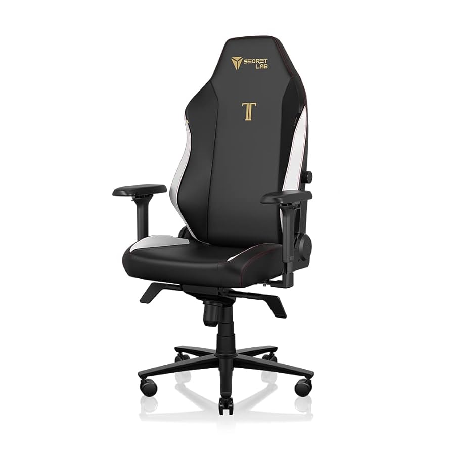 A black and white gaming chair with adjustable armrests, a high backrest, and a five-wheel base. The chair features the Secret Lab logo and the letter "T" in gold on the backrest.